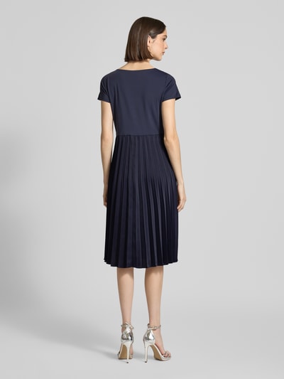 Frauenmodel trägt Midikleid in Plissee-Optik von Christian Berg Woman Selection in Dunkelblau, elastischer Material-Mix, tailliert, Ganzkörperansicht Rückansicht.