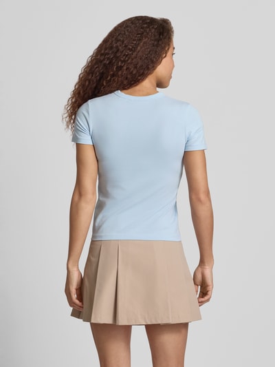 Frauenmodel trägt T-Shirt mit Rundhalsausschnitt Modell 'GIGI' von JJXX aus Baumwoll-Elasthan-Mix in Hellblau, Regular Fit, Rückenlänge 52 cm, Ganzkörperansicht Rückansicht.