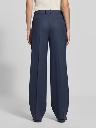 Vrouwenmodel draagt Schmale Hose met wol, model 'Tilda6' van BOSS in donkerblauw; gladde stof, rechte lijnen, Dames broek, volledig zicht van achteren.