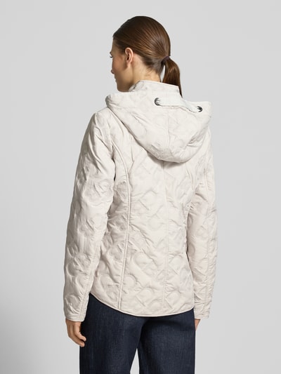 Männermodel trägt Jacke mit Stehkragen und Reißverschlusstaschen von Gil Bret, kolor jasny beż, bawełna, krój taliowany, kaptur z tunelem, tekstura pikowana, Szerokość w rozmiarze 36: 50 cm, długość tyłu: 61 cm, długość rękawa: 64 cm, Szerokość ramion: 37 cm, weatherprotection, Ganzkörperansicht Rückansicht