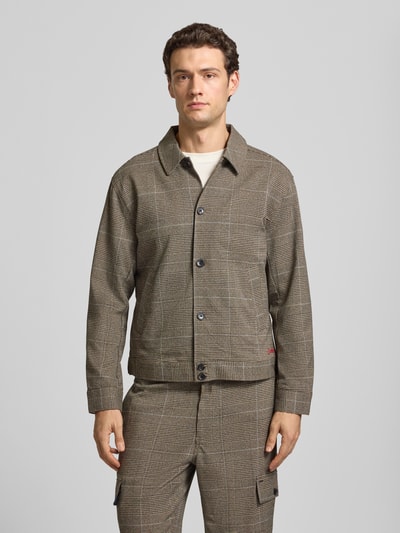 Männermodel trägt Regular Fit Hemdjacke mit Knopfleiste von Scotch & Soda, brauner Material-Mix mit Viskose-Anteil, Allover-Look, Kentkragen, Ganzkörperansicht von vorne