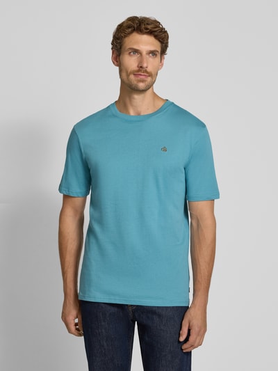Männermodel trägt Regular Fit T-Shirt aus reiner Baumwolle von Scotch & Soda in Blau, Logo-Stitching, Nahaufnahme Oberkörper