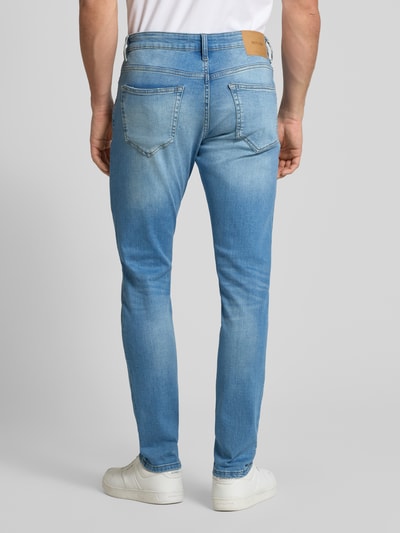 Männermodel trägt Slim Fit Jeans aus Baumwoll-Mix Modell 'LOOM' von Only & Sons in Hellblau mit 5-Pocket-Design, Ganzkörperansicht Rückansicht.