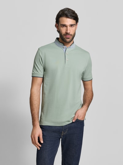 Męski model nosi Regular Fit Koszulka polo z czystej bawełny ze stójką od Christian Berg Men, jasna z krótkim rękawem, listwa guzikowa, elastyczne zakończenia rękawów, długość tyłu w rozmiarze M: 75 cm, widok całej sylwetki od przodu.