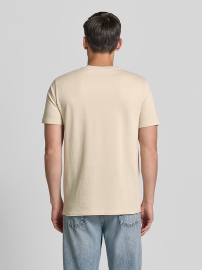 Männermodel trägt T-Shirt mit Rundhalsausschnitt und Label-Stitching von Gant in Beige, reine Baumwolle, Regular Fit, Ganzkörperansicht Rückansicht.