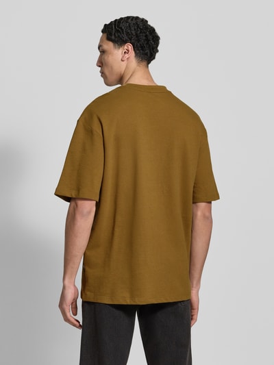 Männermodel trägt entspannt geschnittenes braunes T-Shirt mit Rundhalsausschnitt Modell 'KAISER' von Blend, Rückenansicht, Ganzkörperansicht.