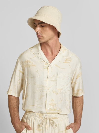 Männermodel trägt Regular Fit Freizeithemd aus Viskose-Mix von MAISON KITSUNÉ in Creme mit Reverskragen und Knopfleiste, Nahaufnahme Oberkörper. Kontext: Kurzärmliges Design, Rückenlänge 71 cm, Schulterbreite 52 cm, Ärmellänge 30 cm.
