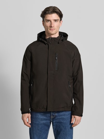 Mężczyzna model nosi Jacke mit Napoleontasche Modell 'KOS' od Killtec, czarna kurtka, kaptur z tunelem, zamek, napoleońska kieszeń, krój regular fit, widok całej sylwetki z przodu