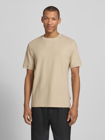 Männermodel trägt Regular Fit T-Shirt aus reiner Baumwolle Modell 'C-TAUT-40' von BOSS in Beige, Struktur Piqué, Ganzkörperansicht von vorne.