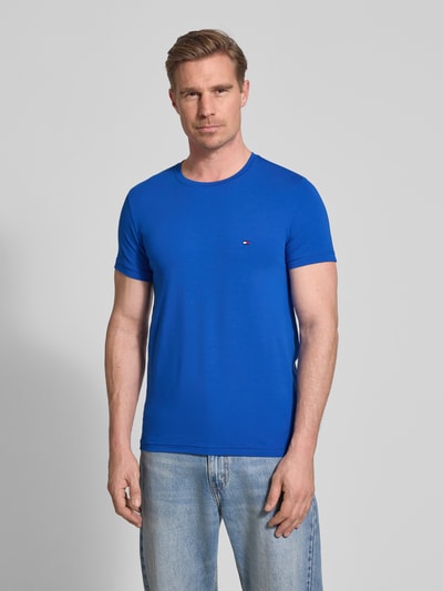 Männermodel trägt Slim Fit T-Shirt aus Baumwoll-Mix von Tommy Hilfiger in Optik: Unifarben, Logo-Detail, Rundhals, Ganzkörperansicht von vorne.