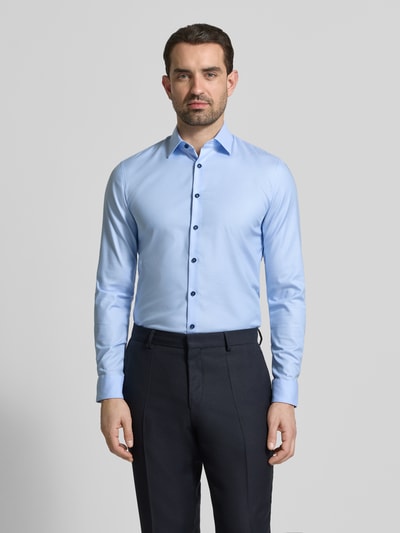 Männermodel trägt Super Slim Fit Business-Hemd mit Kentkragen von OLYMP No. Six, unifarbenes Design, Nahaufnahme Oberkörper.