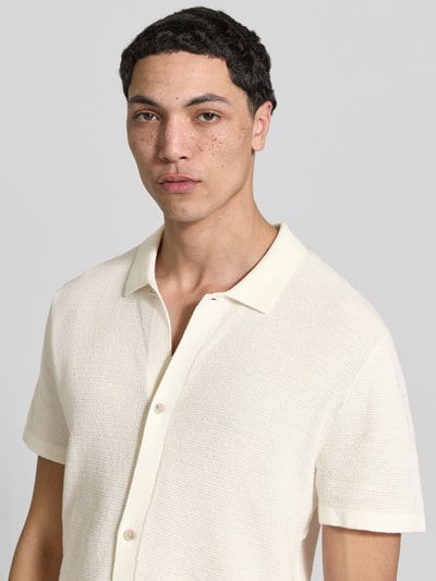 Männermodel trägt Regular Fit Freizeithemd mit Polokragen und Knopfleiste von Jack & Jones, cremefarben, strukturierter Baumwoll-Mix, Nahaufnahme Oberkörper. Modell GEORGE, legerer Schnitt, kurze Ärmel.