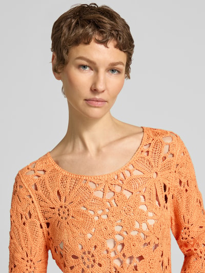 Frauenmodel trägt Strickshirt mit Häkelspitze Modell 'Cornelly' von monari, korallen-orange, Baumwoll-Mix, Nahaufnahme Oberkörper.