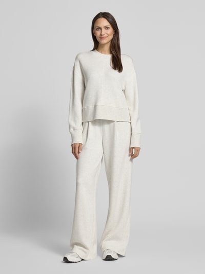 Kobiece model prezentuje Wide Leg Pants aus Viskose-Mix mit elastischem Bund od VARLEY, jasny beż, luźny krój, boczne kieszenie, szerokość w rozmiarze S: 36 cm, długość wewnętrzna nogawki: 84 cm, całopostaciowy widok z przodu