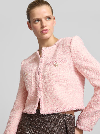 Frauenmodel trägt Cropped Jacke in Bouclé-Optik von Self-Portrait in Rosa mit Paillettenbesatz, Brusttaschen, Rundhalsausschnitt, Nahaufnahme Oberkörper.