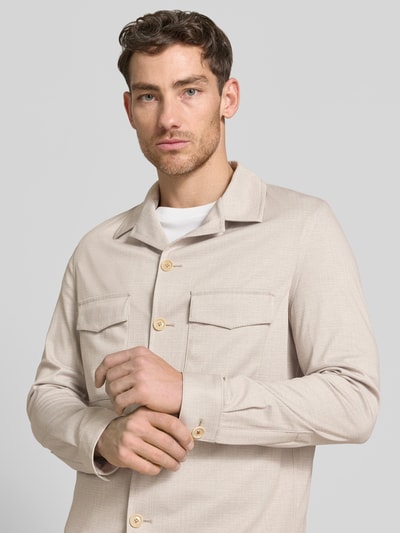 Männermodel trägt Slim Fit Hemdjacke mit Brusttaschen Modell 'Constantin' von CG - Club of Gents in beige, Material-Mix, Nahaufnahme Oberkörper.