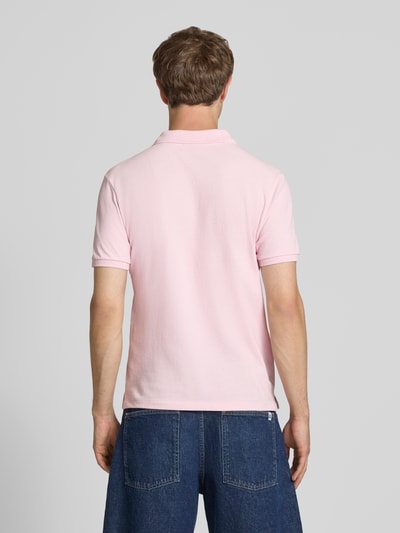 Męski model nosi 'Modern Fit Poloshirt mit Logo-Stitching' od REVIEW, różowa mieszanka bawełny, kołnierzyk polo, listwa guzikowa, długość tyłu w rozmiarze M: 65 cm, widok całej sylwetki od tyłu.