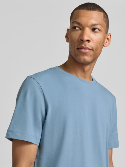 Męski model nosi Regular Fit T-Shirt aus Baumwoll-Mix von Tom Tailor, niebieski, gładka piqué, okrągły dekolt, krótki rękaw, półzbliżenie górnej części ciała