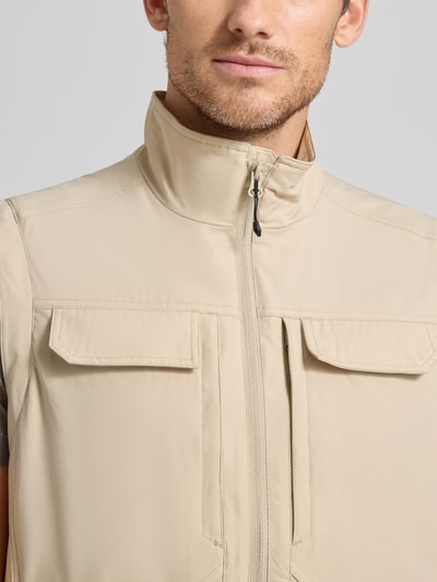 Männermodel trägt Regular Fit Weste mit aufgesetzten Taschen Modell 'Bergheim' von Icepeak in Beige, mit Stehkragen und Reißverschluss, Nahaufnahme Oberkörper. Rückenlänge 67 cm, Schulterbreite 43 cm, Brustweite 57 cm, Eingrifftaschen mit Reißverschluss.
