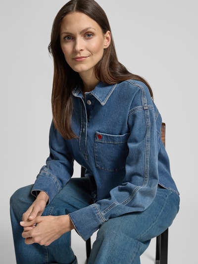 Vrouwenmodel draagt Relaxed Fit Jeansbluse met Stitching model 'Falentine' van OPUS, katoenmix met stretch, knoopsluiting, borstzak, ruglengte maat 36: 57 cm, mouwlengte maat 36: 55 cm, Ganzkörperansicht von vorne.