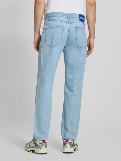 Mężczyzna nosi Straight Fit Jeans aus reiner Baumwolle Modell 'JONAH' von Hugo Blue, jasnoniebieski denim, label patch, 5 kieszeni, widok całej sylwetki z tyłu.