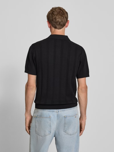 Männermodel trägt Regular Fit Poloshirt mit Logo-Stitching von REVIEW aus reiner Baumwolle, schwarze Farbe, Loch-Stitching, Rückenlänge 56 cm, Ganzkörperansicht Rückansicht.