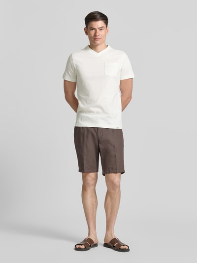 Männermodel trägt Regular Fit T-Shirt mit V-Ausschnitt von Lerros aus weißer Baumwolle mit Brusttasche und Logo-Stitching, Ganzkörperansicht von vorne.