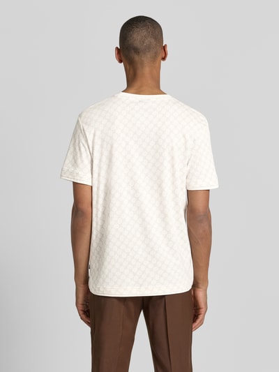 Męski model ma na sobie T-Shirt mit Logo-Muster und Rundhalsausschnitt von JOOP! Collection, bawełniano-lyocellowa mieszanka, krój regular fit, białe z subtelnym wzorem logo, prosty dół, długość pleców w rozmiarze M: 69 cm, widok całej sylwetki z tyłu.