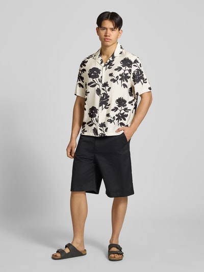 Männermodel trägt Regular Fit Freizeithemd aus Viskose-Mix von REVIEW mit Reverskragen, 1/2-Arm, Knopfleiste, Schwarz-Weiß-Print, Ganzkörperansicht von vorne.