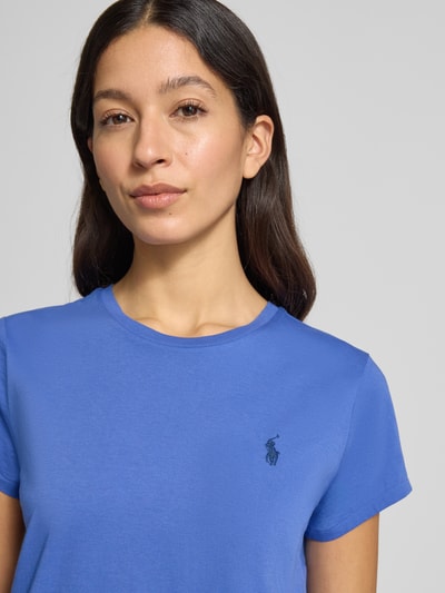 Kobiece modelka nosi T-shirt mit Label-Stitching od Polo Ralph Lauren z bawełny, krój regular fit, okrągły dekolt, kolor niebieski, haftowane logo, widok na górną część ciała z przodu. Długość tyłu w rozmiarze S: 54 cm.