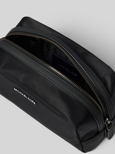 Produktfoto, Travel Kit mit Logo-Applikation Modell 'Brooklyn' von Michael Kors in Schwarz, Reißverschlüsse und Innenfach sichtbar, glatte Textur