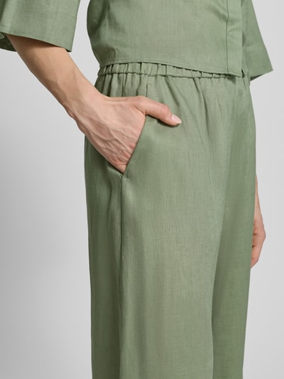 Frauenmodel trägt Culotte aus Leinen mit elastischem Bund Modell 'CANNETI' von MM by Max Mara in hellem Grün, Wide Leg Fit, französische Eingrifftaschen, Nahaufnahme Oberkörper.