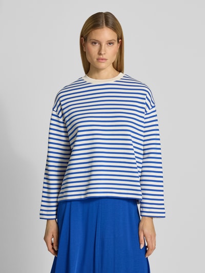 Kobieta modelka ma na sobie bluzę Oversized Sweatshirt aus reiner Baumwolle Modell 'FRANKA MAARLEN' od armedangels w dwukolorowy wzór w paski, wyhaftowane logo, z okrągłym dekoltem i długimi rękawami, wykonana z dzianiny dresowej z czystej bawełny; widok całej sylwetki z przodu.