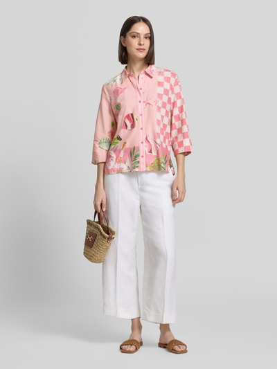 Frauenmodel trägt Bluse aus Viskose-Mix mit Knopfleiste Modell 'Crazy Shirt' von Smith and Soul, rosa mit Muster, Loose-Fit, 3/4-Arm, Hemdblusenkragen, Rückenlänge 64 cm, Ärmellänge 44 cm, Ganzkörperansicht von vorne.