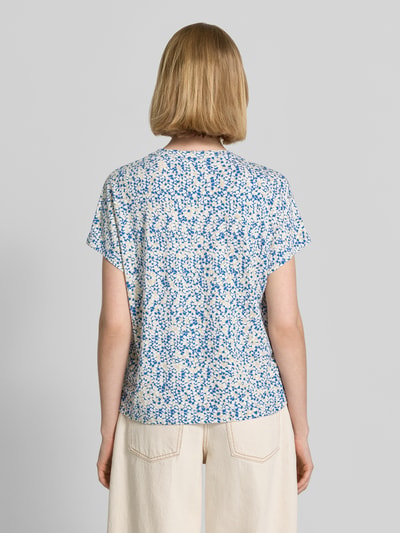 Frauenmodel trägt Relaxed Fit T-Shirt aus Viskose-Mix von s.Oliver RED LABEL mit floralem Allover-Muster in Blau und Weiß, Ganzkörperansicht Rückansicht.