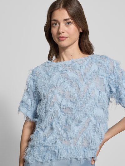 Modelka damska nosi Relaxed Fit Bluzkę z frędzlami model 'MYLINE' od Selected Femme, jednolity kolor, półprzezroczyste detale, krótki rękaw, dekolt łódka, krój relaxed fit, zbliżenie górnej części ciała.