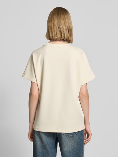 Modelka prezentuje damski t-shirt z mieszanki materiałów z domieszką modalu, krój relaxed fit, model 'BANU' od Soyaconcept, okrągły dekolt, gładka kremowa tkanina, widok sylwetki z tyłu.