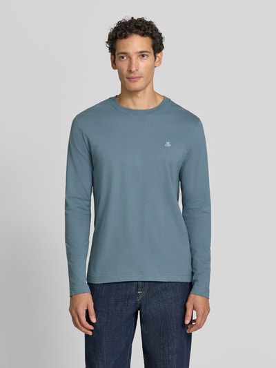 Männermodel trägt Shaped Fit Langarmshirt aus reiner Baumwolle von Marc O'Polo in Blau, glatte Textur, Ganzkörperansicht von vorne.