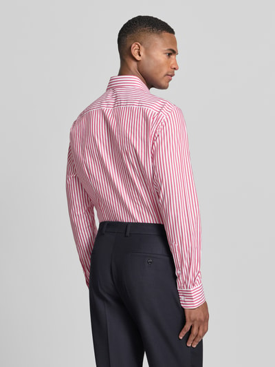 Männermodel trägt Slim Fit Businesshemd aus Baumwoll-Mix von Tommy Hilfiger, Optik:Allover-Muster, gestreift, Ganzkörperansicht Rückansicht.