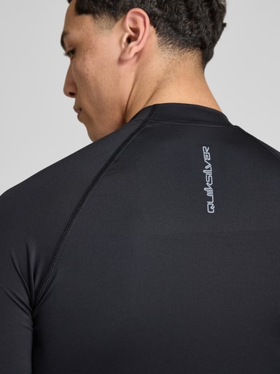 Männermodel trägt Sonnenschutz Wet Shirt Surfshirt mit UPF50 Modell 'EVERYDAY' van Quiksilver, zwarte gladde stof, detailopname rug.