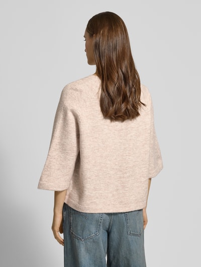 Frauenmodel trägt Oversized Strickpullover mit 3/4-Arm Modell 'SIMONI' von ONLY, unifarbene Melange-Strickoptik, Ganzkörperansicht Rückansicht.