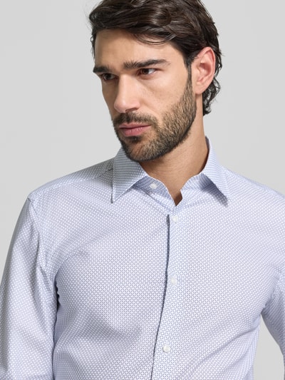 Männermodel trägt Slim Fit Businesshemd aus Lyocell-Baumwoll-Mix Modell 'HANK' von BOSS mit Allover-Muster, Nahaufnahme Oberkörper.