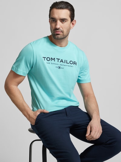 Männermodel trägt Regular Fit T-Shirt aus reiner Baumwolle von Tom Tailor, unifarben, Label Print, Rundhals, Ganzkörperansicht von vorne