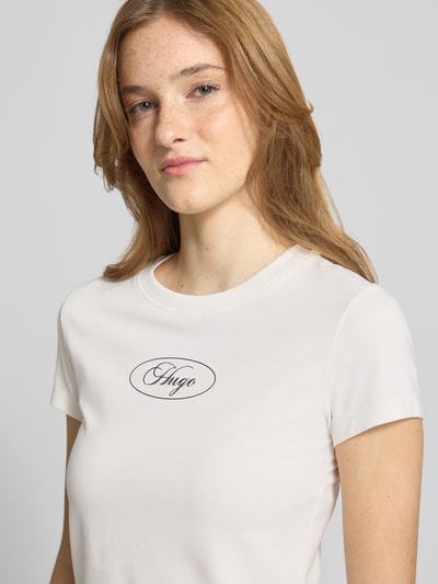 Kobiece model nosi damski t-shirt Regular Fit T-Shirt aus Baumwoll-Mix Modell '90 s TEE_B' od Hugo Blue, jasny kolor, gładka faktura, subtelny nadruk, zbliżenie na górną część ciała.