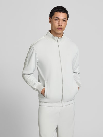 Męskamodel nosi Jacke mit Stehkragen und Eingrifftaschen Modell 'Viro' von Pegador, biały materiał mix z bawełną, krój regular fit, zamek, kieszenie, długość tyłu w rozmiarze M 70 cm, długość rękawa 65 cm, zdjęcie całej sylwetki z przodu.