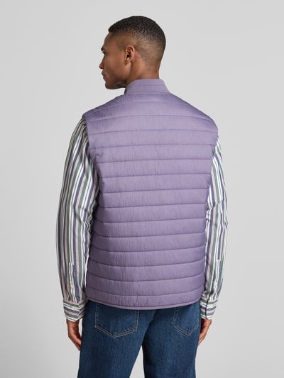 Männermodel trägt Steppweste mit Reißverschlusstaschen von CK Calvin Klein in Flieder, glattes Material, Unifarbenes-Design, Ganzkörperansicht Rückansicht.