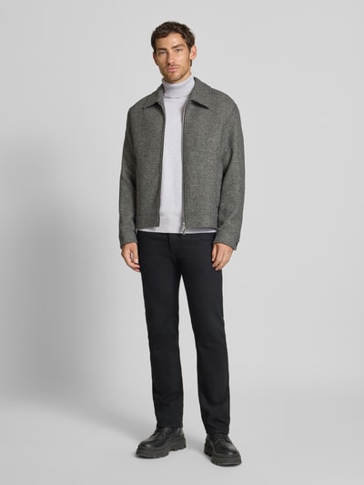 Męski model nosi Regular Fit Rollkragenpullover aus reiner Baumwolle von Tom Tailor Denim w kolorze jasnoszarym, gładka faktura, krój regular fit, patch z logo, rękawy długie z prążkowanym mankietem, dolny brzeg i golf prążkowane, dzianina z czystej bawełny; długość pleców w rozmiarze M: 70 cm, szerokość w rozmiarze M: 54 cm, długość rękawa w rozmiarze M: 64 cm; całopostaciowy widok z przodu.