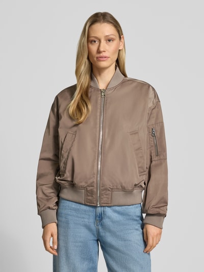 Kobiece model prezentuje Regular Fit Blouson mit College-Kragen od Marc O'Polo, efekt: jednolity kolor, satyna, splot twill, krój regular fit, kołnierz college, zamek błyskawiczny, długi rękaw, prążkowane wykończenia, hydrofobowy, wpuszczane kieszenie, kieszeń zapinana na zamek błyskawiczny na rękawie, wykończenie materiału: splot twill. Ganzkörperansicht z przodu.
