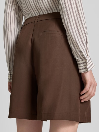 Frauenmodel trägt Bermudas mit französischen Eingrifftaschen von Comma aus Lyocell-Mix mit Leinen-Anteil, Loose-Fit, Detailaufnahme Rückansicht.