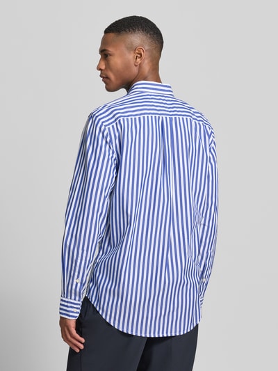 Männermodel trägt Regular Fit Freizeithemd aus Baumwoll-Popeline von Tommy Hilfiger, blau-weiß gestreift, Ganzkörperansicht Rückansicht.